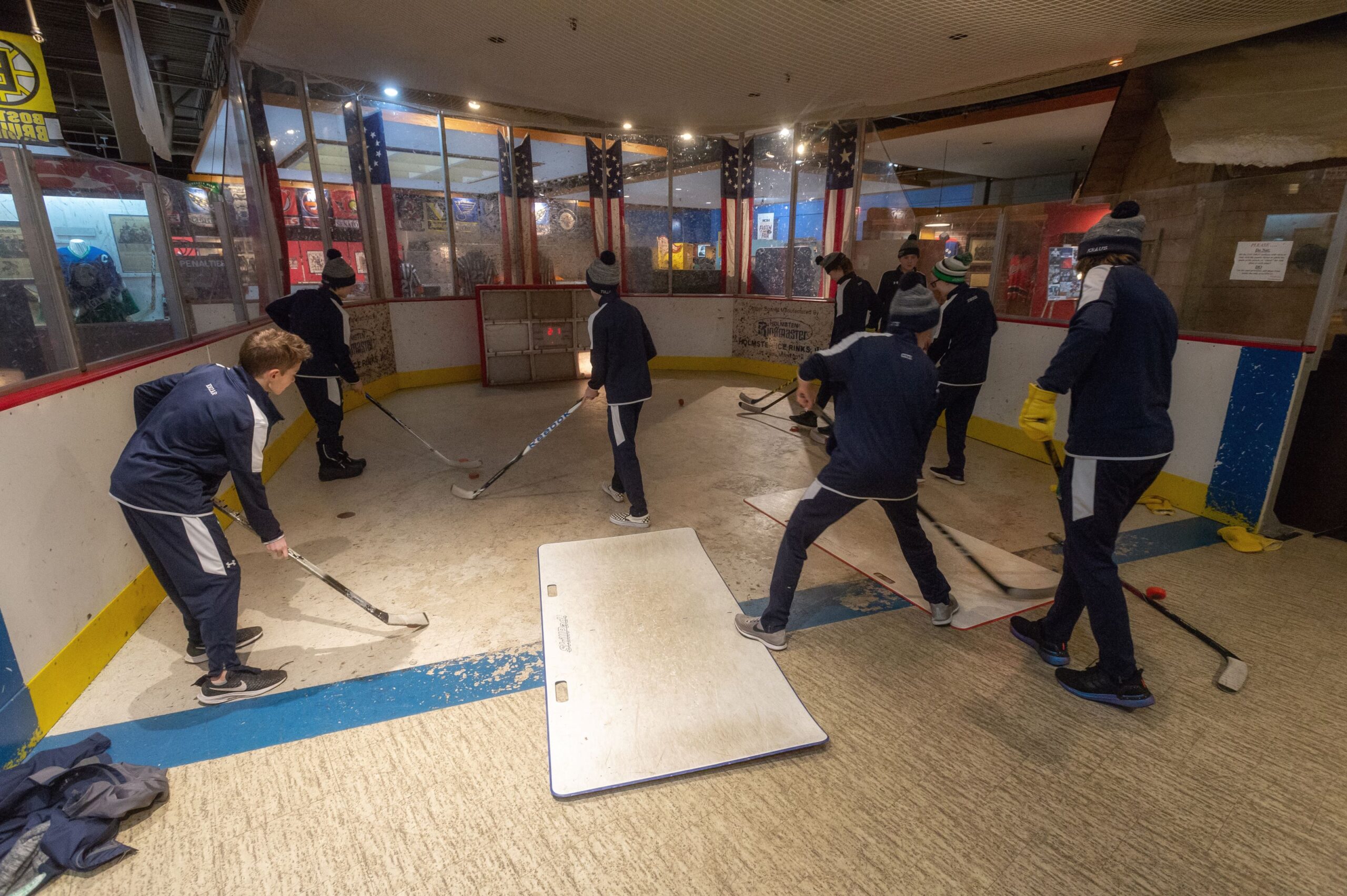 Young people hit hockey pucks in an exhibit at the US Hockey Hall of Fame Museum