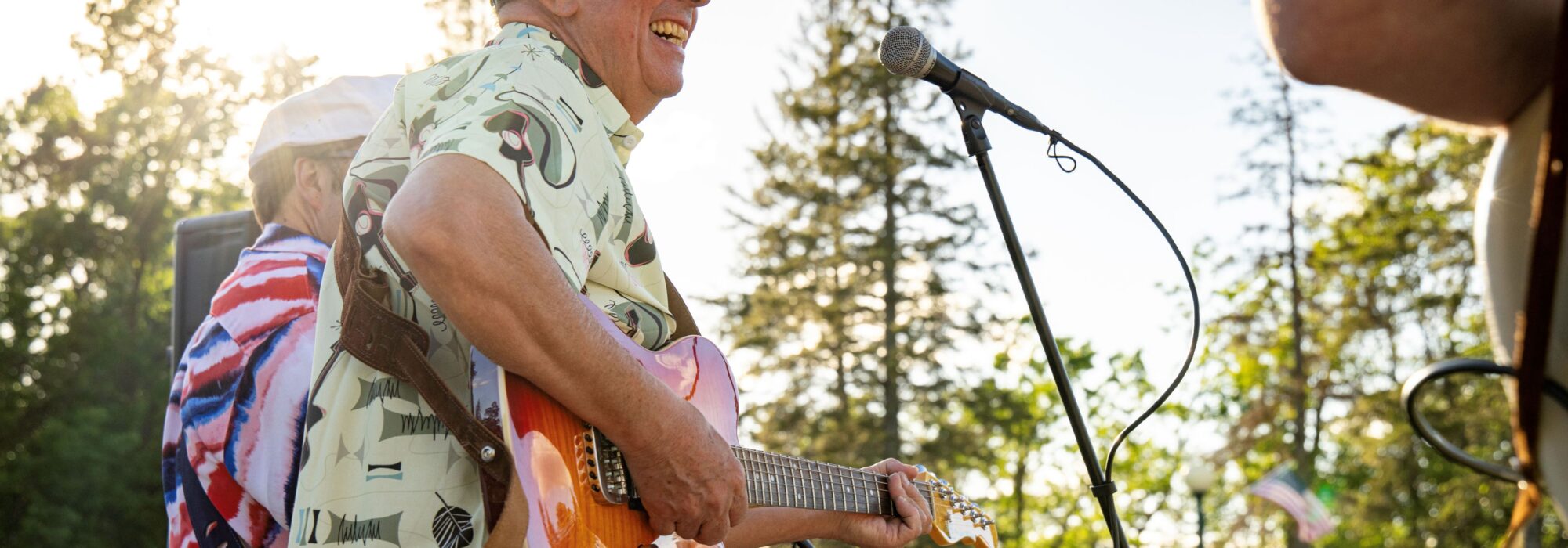 A man plays guitar at an outdoor music event in Virginia, Minnesota