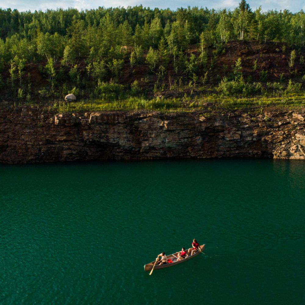 Kayakers paddle across a mine pit lake in northern Minnesota.