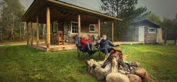 A couple sits by a campfire at Green Gate Guest Houses in Biwabik, MN