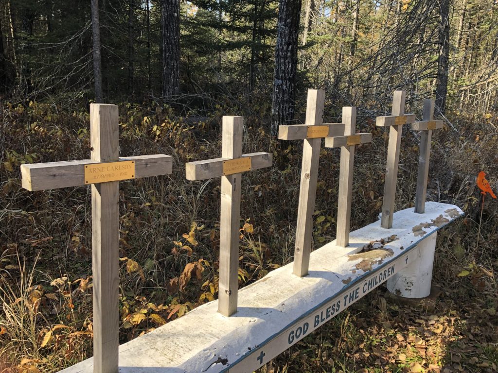 Crosses with names and the words God Bless the Children at the Toimi Children's Cemetery in Minnesota 