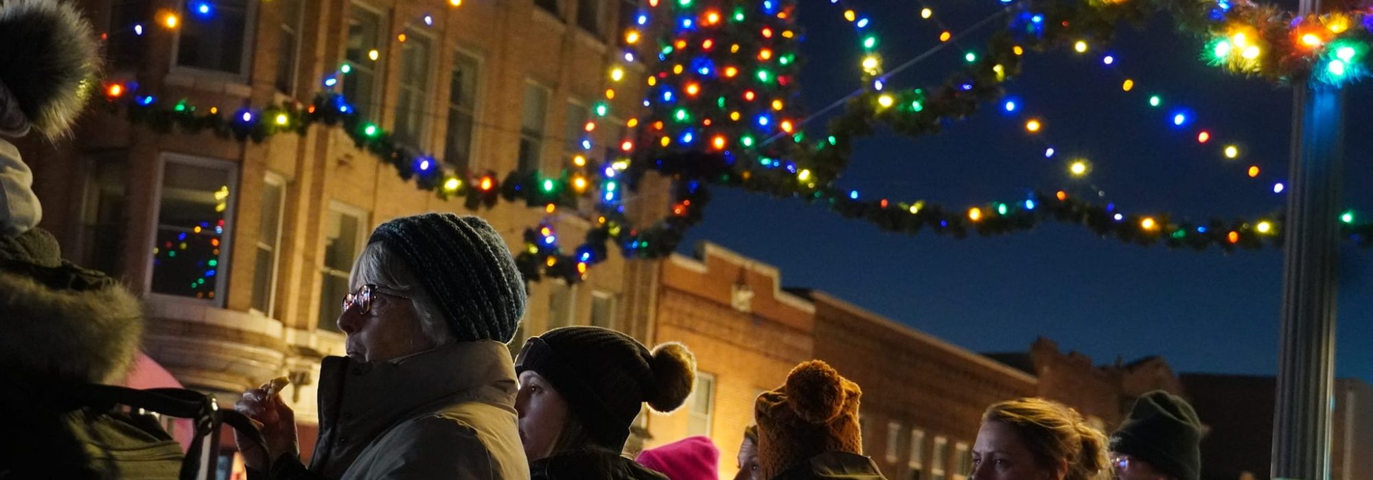 parade goers with holiday lights