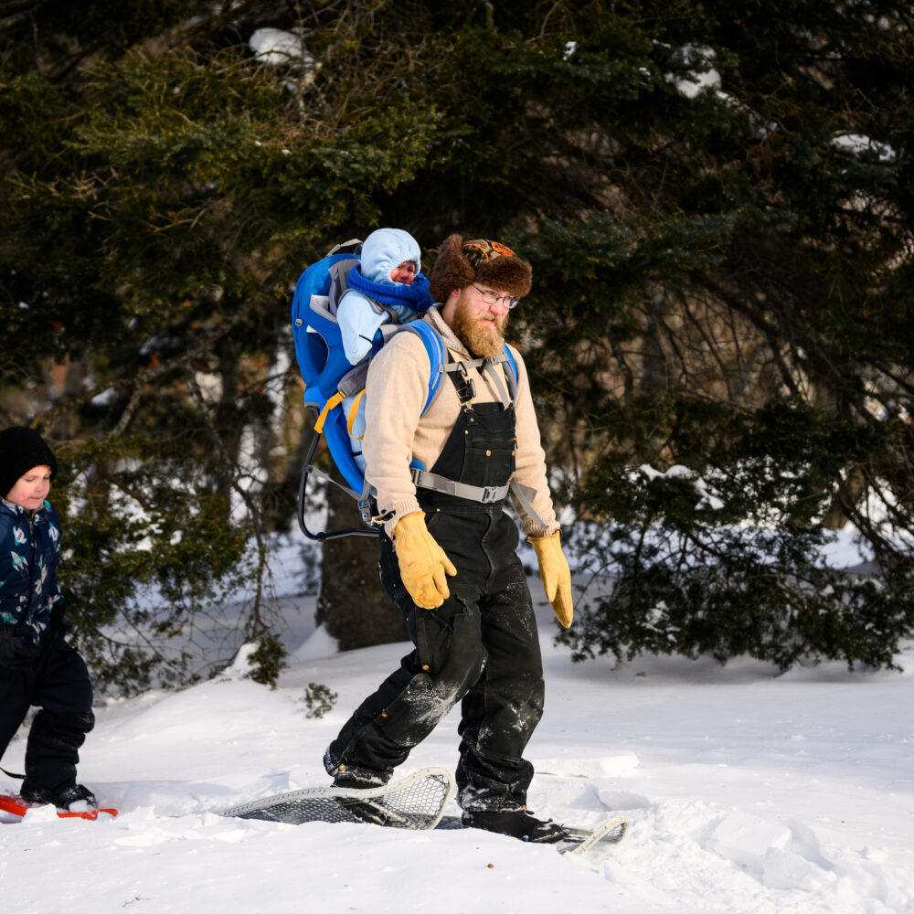 A man snowshoes with his two sons at Minnesota Discovery Center in northern Minnesota