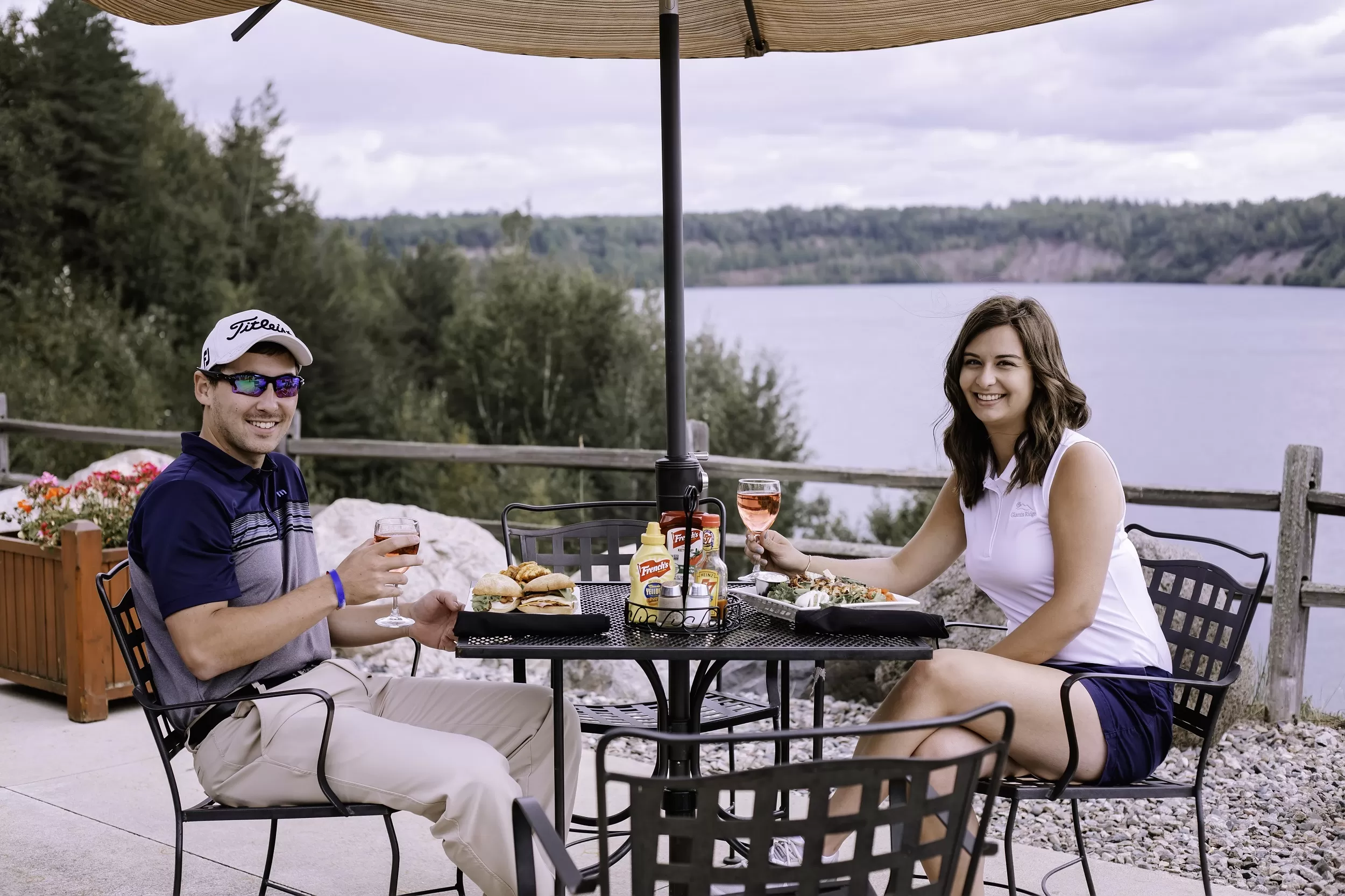 A man and woman enjoy a meal on the patio of the Wacootah Grille at Giants Ridge Resort 