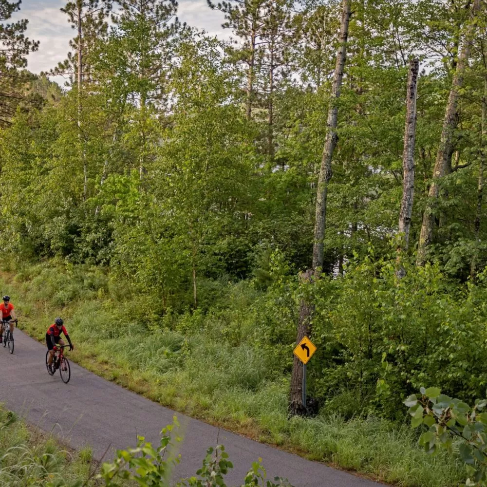Three cyclists bike along the paved Mesabi Trail in northern Minnesota.
