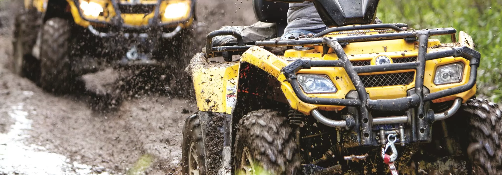 ATV riders splash through a puddle on Minnesota's Iron Range