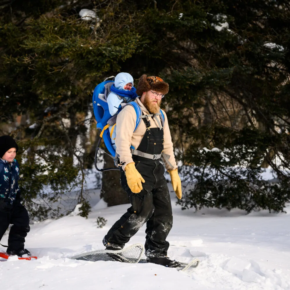 A man snowshoes with his two sons at Minnesota Discovery Center in northern Minnesota